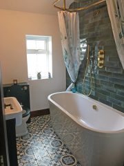 New bathroom refurbishment with green metro tiles and patterned floor tiles, by Thomson Properties