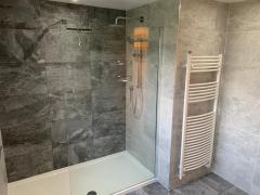 Grey bathroom refurbishment with rain shower - Thomson Properties, bathroom refurbishment specialists Surrey and Sussex