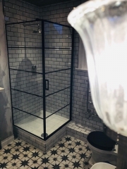 Patterned bathroom floor tiles, black fittings with white brick wall tiles - Thomson Properties