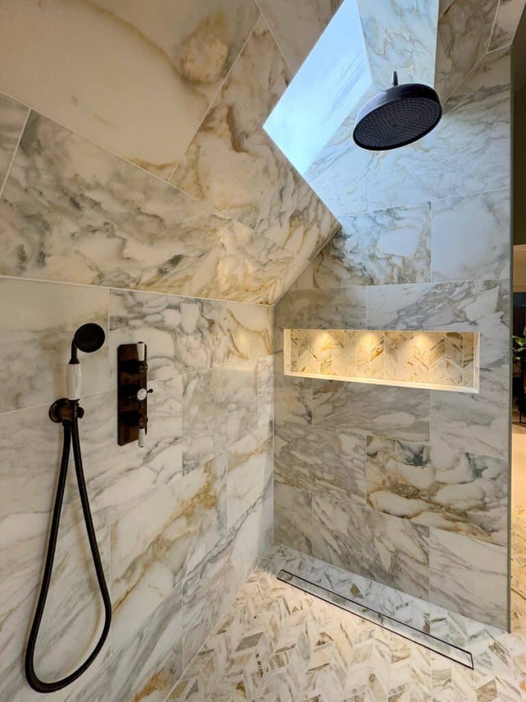 Rainfall shower and illuminated shelf in the Rudgwick marble steam room.