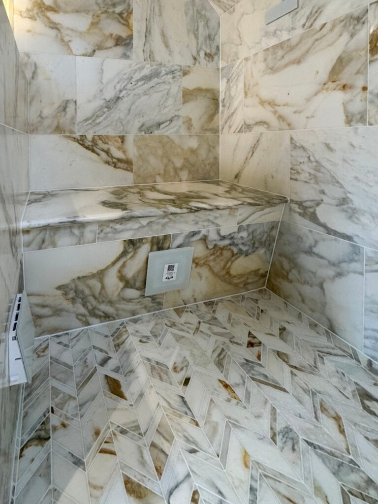 Built-in marble seat above the steam room floor.