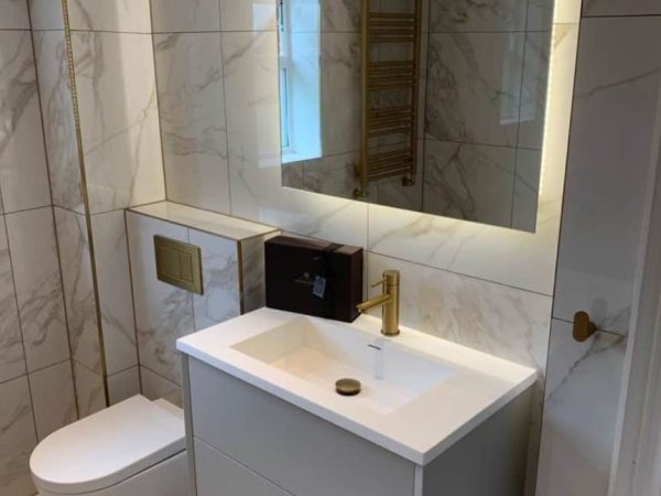 Grey bathroom vanity with a white basin and mirrored cabinet