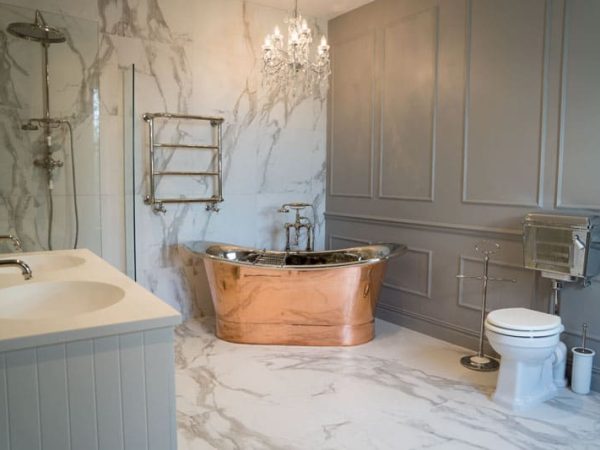 Bathroom with a copper-coloured bath and double basin vanity