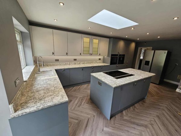 Contemporary kitchen with herringbone wooden flooring and modern appliances.